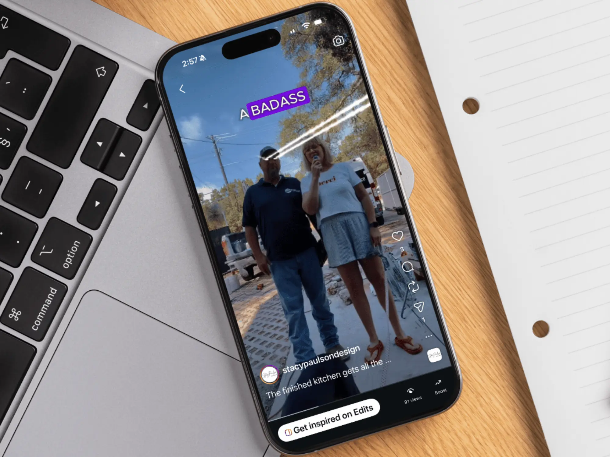 A branded social post playing on a phone resting on a laptop