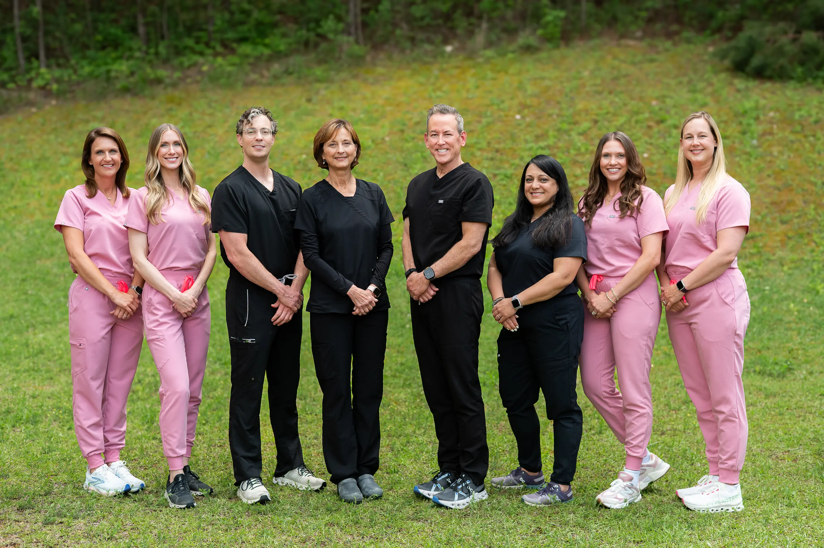 An outdoor team portrait of a practice's staff, professionally lit and styled